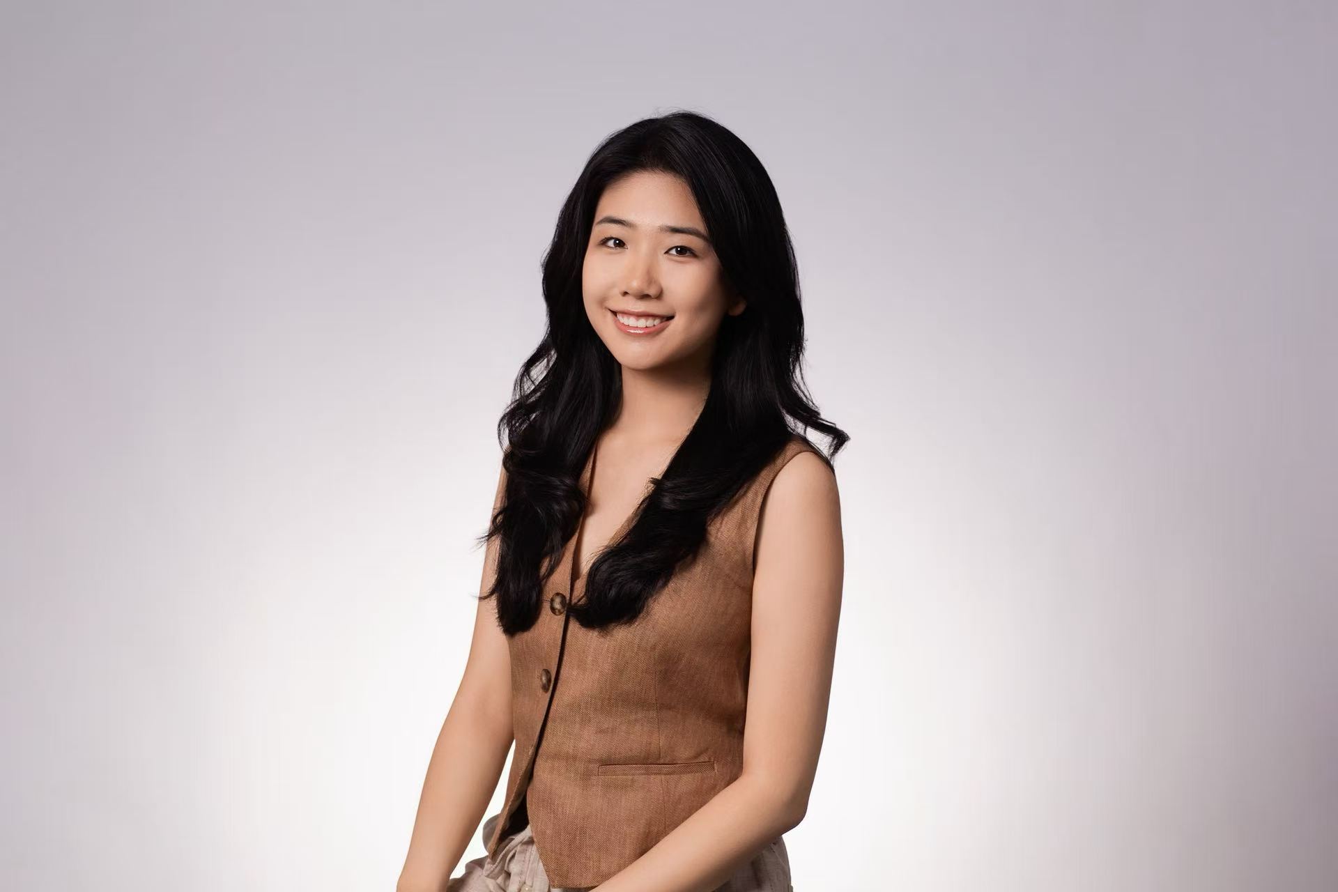 Jiayu Shao smiling against a neutral studio background